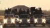 FILE - An image grab taken from a video released by Islamic State group's official Al-Raqqa site via YouTube allegedly shows Islamic State (IS) group recruits riding in armed trucks in an unknown location. 