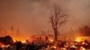 Buildings burn as the Dixie Fire tears through the Greenville community of Plumas County, Calif., on Aug. 4, 2021.