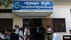 អ្នក​យក​ព័ត៌មាន​ចោមរោម​នៅ​មុខ​មជ្ឈមណ្ឌល​កុំព្យូទ័រ​បស់​គណៈកម្មាធិការ​ជាតិ​រៀប​ចំ​ការ​បោះឆ្នោត។