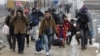 People walk from the transit center for refugees towards the border with Serbia, near the northern Macedonian village of Tabanovce, Jan. 26, 2016.
