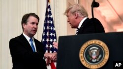 Le président américain de l'époque, Donald Trump, serre la main du juge Brett Kavanaugh, avant sa prestation de serment la Maison Blanche, le 8 octobre 2018.