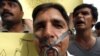 A journalist is seen with a padlock in front of his mouth as others protest against media curbs and emergency rule in Islamabad November 20, 2007. REUTERS/Faisal Mahmood (PAKISTAN)
