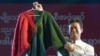 FILE - Myanmar actor Pyay Ti Oo displays a jumper knitted by then-opposition leader Aung San Suu Kyi, at an auction in Yangon, Myanmar, Dec. 27, 2012. He and two other Myanmar celebrities reportedly have been jailed for speaking out against the February coup.