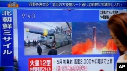 A woman walks past a TV screen broadcasting news of North Korea's missile launch, in Tokyo, Aug. 29, 2017. North Korea fired a ballistic missile from its capital Pyongyang that flew over Japan before plunging into the northern Pacific Ocean.