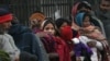 FILE - Indian homeless people wait for free food outside a temple, in New Delhi, India, Jan. 1, 2013.