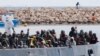 FILE - After more than 300 migrants died Friday trying to cross the Mediterranean, other migrants arrived by boat at the Sicilian harbor of Pozzallo, Italy, Feb.15, 2015. 