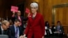 An anti-war protestor holds up signs as Undersecretary of State for Political Affairs Wendy Sherman arrives on Capitol Hill in Washington, Feb. 4, 2014, to testify before the Senate Foreign Relations Committee hearing examining negotiations on Iran's nuclear program.