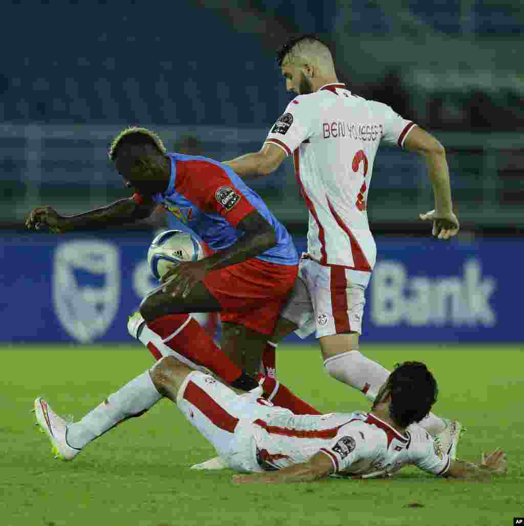 Loteteka Jeremy Bokila de la RD Congo, à gauche, est aux prises avec Mohamed Ali Yaacoubi de la Tunisie, couché, et Syam Youssef lors de leur match de football de la Coupe d'Afrique des nations Groupe B à Bata, en Guinée équatoriale, lundi 26 janvier 2015.