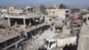 Residents inspect damage at a site hit by one of three explosive trucks, in the YPG-controlled town of Tel Tamer, Syria, Dec. 11, 2015. 