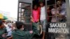 Cambodian migrant workers get off from a Thai truck upon their arrival from Thailand at Cambodia-Thai international border gate in Poipet, Cambodia, Tuesday, June 17, 2014. The number of Cambodians who have returned home from Thailand this month after a threatened crackdown on foreigners working illegally has topped 160,000, a Cambodian official said Monday. Thai officials insist the cross-border movement is voluntary and is not forced repatriation. They say Thai military and government resources were used to transport workers who decided to return home after being laid off because they were working illegally. (AP Photo/Heng Sinith)