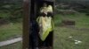 A Syrian woman with her children takes a shelter in a iron box during a rainfall, after they arrived from Turkey to the Greek deserted island of Pasas near Chios on Wednesday, Jan. 20, 2016 .