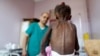 FILE - A nurse looks as he weighs a malnourished girl at a malnutrition treatment center in Sanaa, Yemen, Oct. 7, 2018.