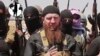 FILE - Abu Omar al-Shishani, also known as "Omar the Chechen," stands next to Islamic State fighters as they declare elimination of border between Iraq and Syria.