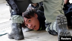 Muandamanaji yuko mikononi mwa polisi wa kuzuia ghasia wakati wa maandamano ya dhidi ya serikali yakifanyika Hong Kong, China, Novemba 10, 2019.
