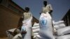 FILE - Sacs of sorghum are stored following the delivery of nearly 50,000 tonnes of US food aid bound for areas of Sudan affected by conflict, on May 26, 2015. in Port Sudan. T