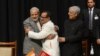 Indian Prime Minister Narinder Modi, left, and Jammu and Kashmir Deputy Chief Minister Nirmal Singh, center, embrace as Jammu and Kashmir Chief Minister Mufty Mohammed Sayeed looks on during a swearing-in ceremony of the state assembly in Jammu, March 1, 2015.