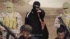 FILE - An Islamic State militant holds a gun while standing behind what are said to be Ethiopian Christians in Wilayat Fazzan, in this still image from an undated video made available on a social media website on April 19, 2015.