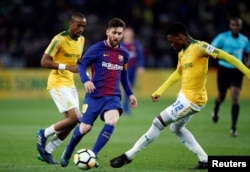Barcelona Lionel Messi (L) plays the ball during a friendly match between Barcelona v Mamelodi Sundowns for the Mandela Centenary Trophy at FNB Soccer Stadium in Johannesburg, South Africa, May 16, 2018.