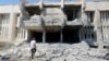 FILE - A man inspects damage at the entrance of the National Hospital of al-Tabqa, caused by what activists said was an airstrike by forces of Syria's President Bashar Al-Assad on the hospital, beside al-Tabqa military base, west of Raqqa, Aug. 23, 2014. 