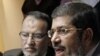Pemimpin Ikhwanul Muslimin, Essam el-Erian (kiri) dan Mohamed Morsi memberikan konferensi pers di Kairo (9/2).