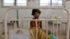 FILE - A girl, who fell sick after consuming contaminated meals given to children at a school on Tuesday, rests inside a hospital in the eastern Indian city of Patna, July 18, 2013.