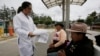 Un trabajador de la salud en Ecuador distribuye información a personas en una estación de bus, como parte de una campaña de prevención.