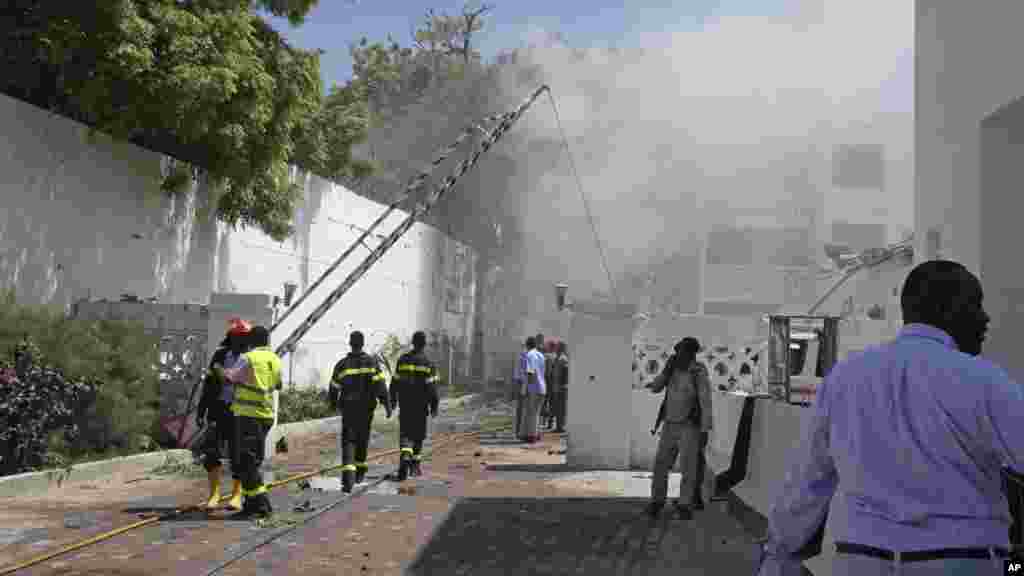 La fumée et la vapeur continuent à s'élever après que les falmmes ont été éteintes couvre le lieu d'une double attaque dans un hôtel à Mogadiscio, en Somalie.