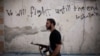 FILE - Free Syrian Army fighter walks through a street in the Amariya district in Aleppo, Syria. 