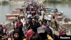 Displaced Sunni people fleeing Ramadi cross a bridge outside Baghdad, May 24, 2015. Iraqi forces recaptured territory from advancing Islamic State militants near the recently fallen city of Ramadi on Sunday.