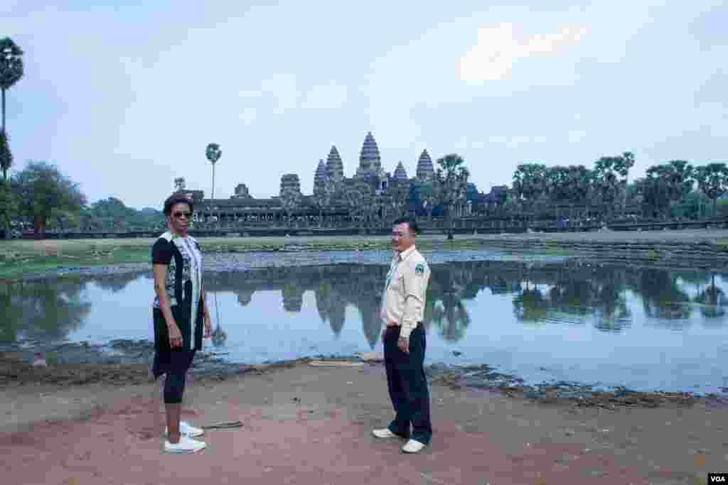 មគ្គុទ្ទេសក៍​ទេសចរណ៍​បង្ហាញ​ដល់​លោកស្រី Michelle Obama ក្នុង​ពេល​ដើរ​ទស្សនា​នៅ​បរិវេណ​ប្រាសាទ​អង្គរវត្ត នៅ​រសៀល​ថ្ងៃសៅរ៍​ទី២១ ខែមីនា ឆ្នាំ២០១៥។ (នៅ វណ្ណារិន/VOA)