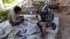 FILE - In this file photo released on June 16, 2015, by Islamic State militant group supporters on an anonymous photo sharing website, Islamic State militants clean their weapons in Deir el-Zour city, Syria.
