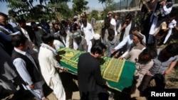 FILE - Afghans take part in the burial of an Afghan journalist in Kabul, Afghanistan, June 7, 2016. 