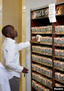A man buys bread at a supermarket in Harare, Zimbabwe, Oct. 9, 2018. The sign at the top reads, "Only two loaves per customer, please."