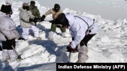 An Indian army soldier cuts through ice and snow in the search for survivors after a deadly avalanche on the Siachen glacier, Feb. 8, 2016. An Indian soldier was rescued Tuesday, six days after being buried in the avalanche.