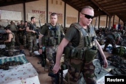FILE - French soldiers leave a hangar at the Malian army air base in Bamako, Jan. 14, 2013. France had poured hundreds of troops into Bamako at the time, carrying out air raids in a vast desert area seized the year before by an Islamist alliance grouping al-Qaida's north African wing, AQIM, and Mali's homegrown MUJWA and Ansar Dine militant groups.