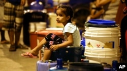 A Filipino girl waits for trucks bearing water after supply has been out for the past days in Mandaluyong, metropolitan Manila, March 14, 2019.