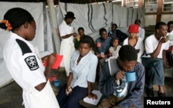 FILE - Cholera patients drink treated water inside an admission ward at Budiriro Polyclinic in Harare, Zimbabwe.
