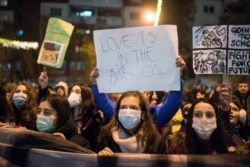 People wearing masks participate in a protest against air pollution in Skopje on December 20, 2019