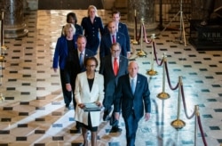 FILE - Clerk of the House Cheryl Johnson, left, and House Sergeant at Arms Paul Irving pass through Statuary Hall at the Capitol to deliver the articles of impeachment against President Donald Trump to the Senate, Jan. 15, 2020.
