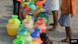 Indian residents queue with plastic containers to get drinking water from a tanker in the outskirts of Chennai, May 29, 2019. An unrelenting heat wave triggered warnings of water shortages and heatstroke in India on June 1.