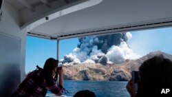 Foto oleh Michael Schade, tampak para turis mengabadikan letusan gunung berapi di White Island, Selandia Baru, 9 Desember 2019. 