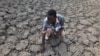 FILE - Last Zimaniwa feels the broken ground at a spot which is usually a reliable water source that has dried up due to lack of rains in the village of Chivi , Zimbabwe, Jan. 29, 2016. Southern Africa's lengthy drought has gotten worse, aid officials say