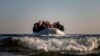 FILE - Refugees and migrants approach the Greek island of Lesbos on a dinghy after crossing the Aegean sea from the Turkish coast, on Monday, Dec. 7, 2015. 