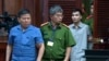 FILE - Australian man Chau Van Kham, left, is escorted into a court room in Ho Chi Minh city, Vietnam, Nov. 11, 2019. 