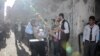 FILE - A man carries an injured child after four rockets fired from Syria slammed into the southern Turkish town of Kilis, killing four Syrians — including three children — in the latest deadly cross-border strike to panic residents, April 18, 2016.