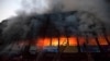 Locals and fire-fighters try to control a fire at a garment factory in Dhaka, March 6, 2014. 