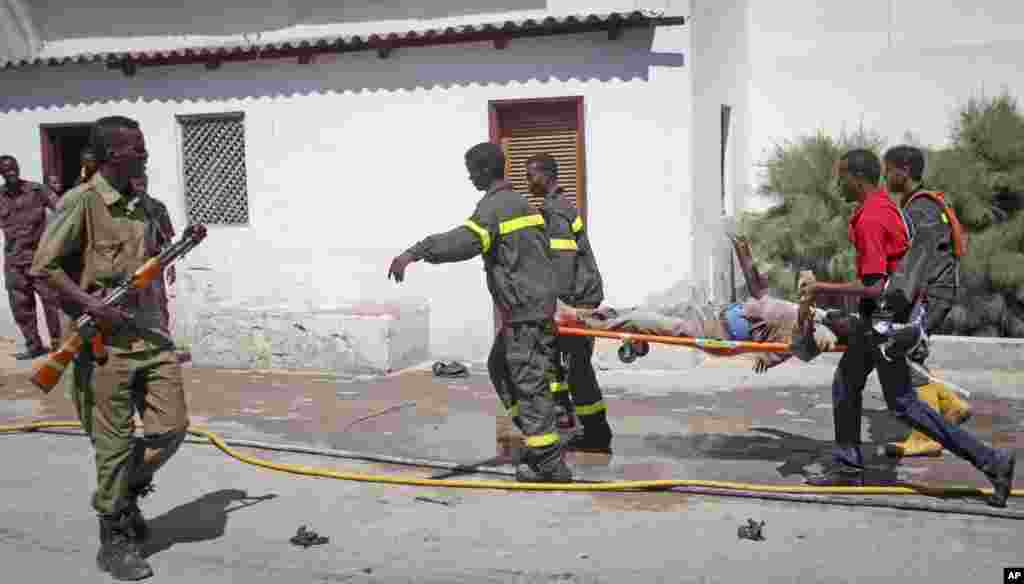 Une équipe de secours somalienne emporte le corps d'un civil mort au lieu d'une attaque à la bombe dans un hôtel à Mogadiscio, en Somalie.