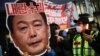 Un manifestant tient une pancarte cartonnée représentant le président déchu Yoon Suk Yeol avec l'inscription « Leader des insurgés » lors d'une manifestation appelant à sa destitution, le 8 décembre 2024 à Séoul. AFP / Philip Fong