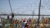 Visitors hang a ribbon on a wire fence decorated with other ribbons at the Imjingak Pavilion in Paju, South Korea, Tuesday, June 9, 2020. North Korea said Tuesday it will cut off all communication channels with South Korea as it escalates its…