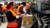 Employees handle packages in the new Amazon logistics center in Dortmund, Germany, Nov. 14, 2017.